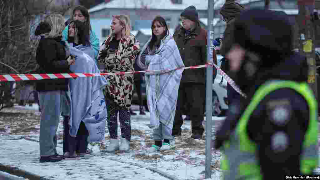 Civilek a fagyos időben kijevi lakóházuk mellett.&nbsp;Kijevben legalább húsz ember sérült meg, köztük egy tizenhárom éves fiú &ndash; közölte Vitalij Klicsko polgármester