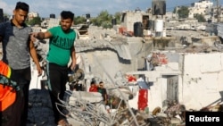 Palestinezët duke kërkuar për persona të bllokuar pas shkatërrimit të një shtëpie nga një sulm izraelit në Han Junis. 19 tetor 2023.