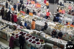 People shop for traditional Chinese medicine at a herbal market in Bozhou, in eastern China's Anhui province, in February.