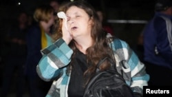 An injured woman leaves her apartment building in Odesa after it was hit by a Russian missile strike on October 11.