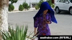 Mobil telefonyna seredip barýan zenan (Illýustrasiýa suraty)