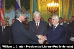 В то время президент США Билл Клинтон (слева направо), президент России Борис Ельцин и президент Украины Леонид Кравчук пожимают друг другу руки в Москве, 14 января 1994 года