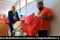 Papa Francisc sărută un banner de 50 de metri lungime, cu numele a 4.120 de copii indigeni care au murit sau au dispărut în școlile rezidențiale, în timpul vizitei sale la Maskwacis, 25 iulie 2022.