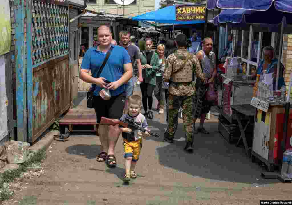 Egy kisfiú műanyag fegyverrel a kezében a Donyeck megyei Kosztyantinivkában június 25-én
