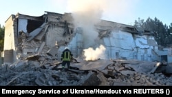Vatrogasac na mestu školske zgrade uništene ruskim vojnim udarom, Mikolajev, Ukrajina, 14. jula 2022.