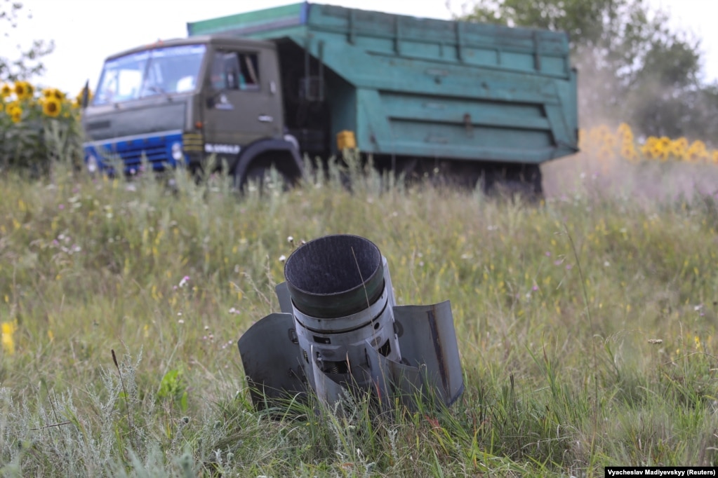 Një kamion i ngarkuar me grurë duke kaluar pranë një pjese të një rakete të ngulitur në një fushë në rajonin e Harkivit më 30 korrik.
