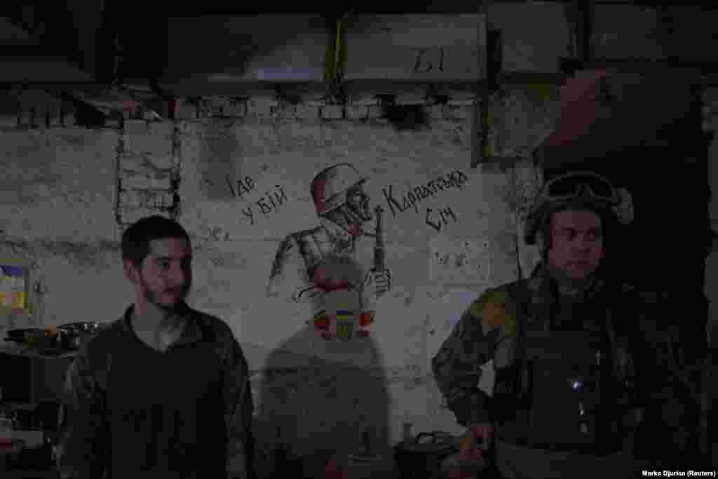 Members of the battalion stand next to a drawing of a soldier with the words &quot;Goes to the battle Carpathian Sich&quot; inside the group&#39;s forward operating base in the Kharkiv region. Polishchuk speaks about the threat of capture: &quot;It&#39;s not going to stop me. It&#39;s not going to change my decision. It&#39;s definitely something that you have to keep in mind and consider, but at the same time, this is war. We all know the possible consequences of us being here, and we&#39;ve all made peace with that.&quot;