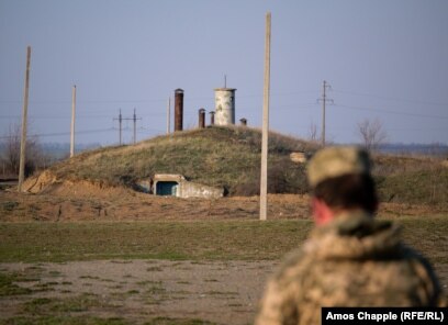 Një ushtar ukrainas qëndron pranë një hyrje në bazën e raketave Pervomaysk në prill 2019.