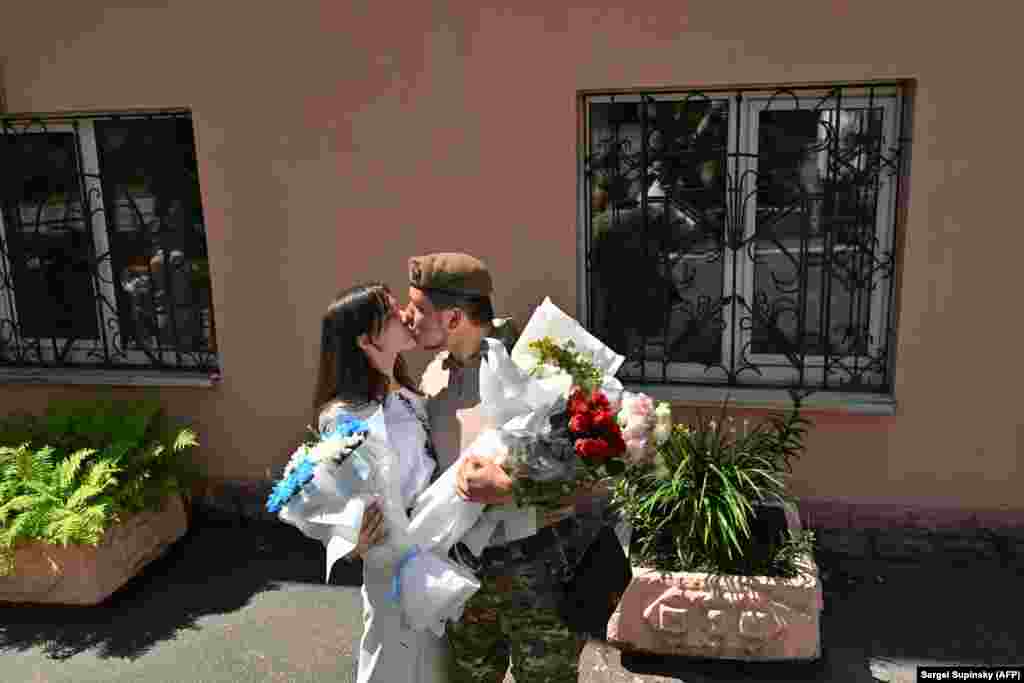 Ushtari ukrainas, Vitaliy, 25 vjeç, duke puthur gruan e tij disa momente pasi dyshja shkëmbyen betimet në Kiev më 23 korrik. Që nga pushtimi rus më 24 shkurt, Ukraina ka parë një nxitim të paprecedent drejt altarit: 9.120 martesa janë regjistruar në pesë muajt e fundit në Kiev, krahasuar me 1.110 të regjistruara gjatë së njëjtës periudhë të vitit 2021. &nbsp;