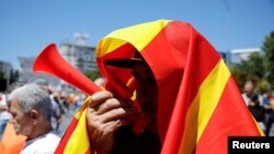 Učesnik protesta ispred makedonskog Sobranja, na visokoj temperaturi, iskazuje nazadovoljstvo "francuskim predlogom" u trenetku zasjednja državnog parlamenta 14. jula 2022.