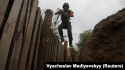 A member of the Ukrainian National Guard jumps into a trench at a position near the front line in the Kharkiv region on August 3.