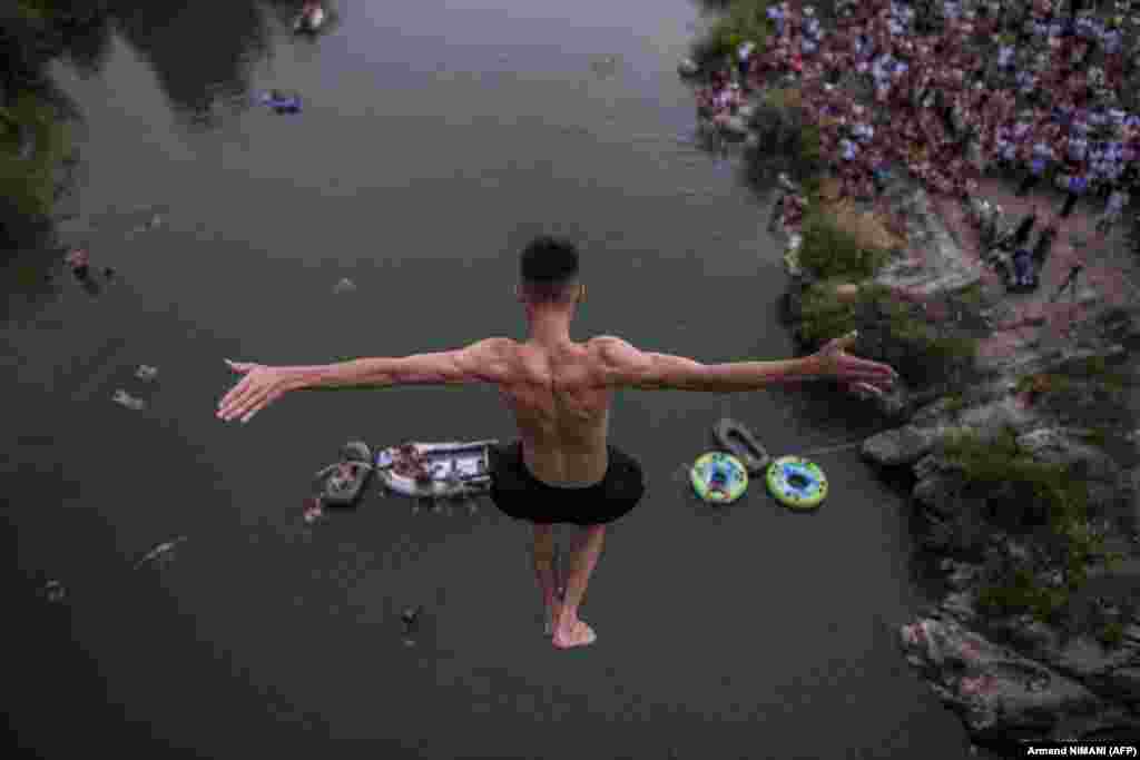 Muškarac skače sa mosta visokog 22 metra tokom godišnjeg takmičenja u skokovima u vodu u blizini grada Đakovica na Kosovu.