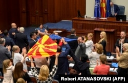  Депутати в македонския парламент развяват знамената на Северна Македония и на Европейски Съюз след гласуването в поддръжка на френското предложение. Снимката е от 16 юли 