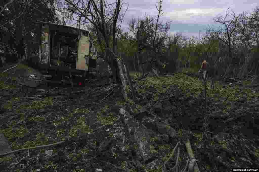 On the outskirts of Pokrovsk, a man walks away from a crater left by a Russian missile that killed 35-year-old Anna Protsenko, who herself had just returned home.