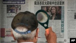 Un bărbat citește cu o lupă un titlu de ziar despre vizita președintei Camerei Reprezentanților de la Washington în Taiwan, Pekin, 31 iulie 2022. 