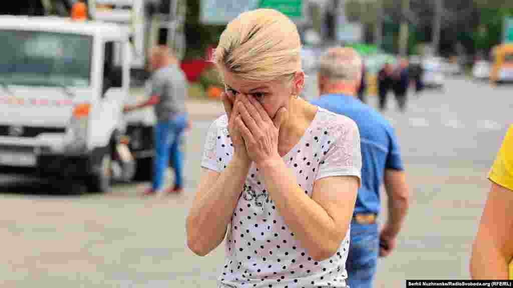 Жінка плаче біля місця, де загинули люди під час ракетного обстрілу у Вінниці