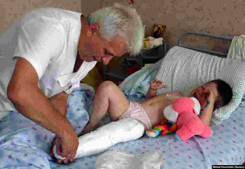 Voldya, 7, who was hurt in the air show disaster, cries as surgeon Ivan Fedorko treats his leg at a children&#39;s hospital in Lviv on July 28, 2002.