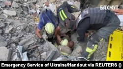 Spasioci pažljivo izvlače muškarca 28. jula iz ruševina hotelske zgrade pogođene ruskim napadom u Bakhmutu, u Ukrajini, dan ranije.