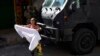 Stanovnica maše bijelom plahtom u znak prosvjeda i traženja mira nakon policijske operacije koja je rezultirala višestrukim smrtnim slučajevima, u faveli Complexo do Alemao u Rio de Janeiru, Brazil, četvrtak, 21. jula 2022.