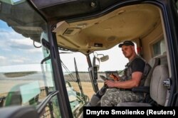 Poljoprivrednik ukrajinske regije Zaporožje nosi pancir dok vozi kombajn, 29. srpnja.