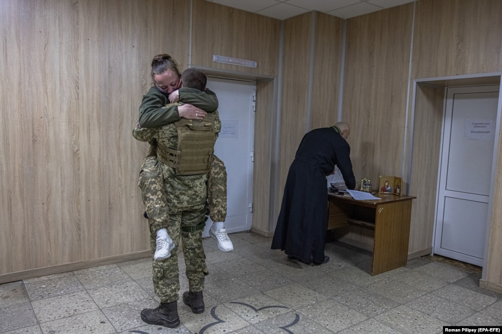 Ushtarët e porsamartuar duke u përqafuar pasi kanë shkëmbyer betimet në rajonin Brovari, afër Kievit, gjatë rrethimit rus të kryeqytetit ukrainas. Dyshja, që kërkuan të mos u përmendeshin emrat, u takuan për herë të parë në Ukrainën lindore në vitin 2015 derisa luftonin kundër separatistëve të mbështetur nga Rusia. Ata filluan një marrëdhënie pasi u ribashkuan rastësisht në mes të pushtimit rus të vitit 2022.  