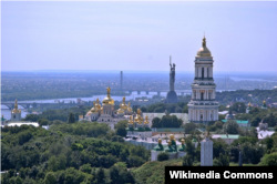 Вигляд на Києво-Печерську Лавру та монумент Батькіщини-матері. За переказами киян, меч монументу було укорочено через протести, що в початковому проєкті він передбачався вищим за хрест дзвінниці Лаври