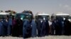 Displaced Afghan women wait to receive cash aid for displaced people in Kabul.