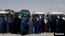 Displaced Afghan women wait to receive cash aid for displaced people in Kabul.