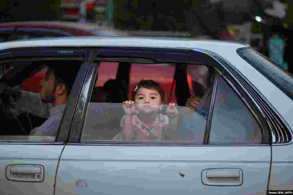 A little girl looks out the window of a car in Kabul.