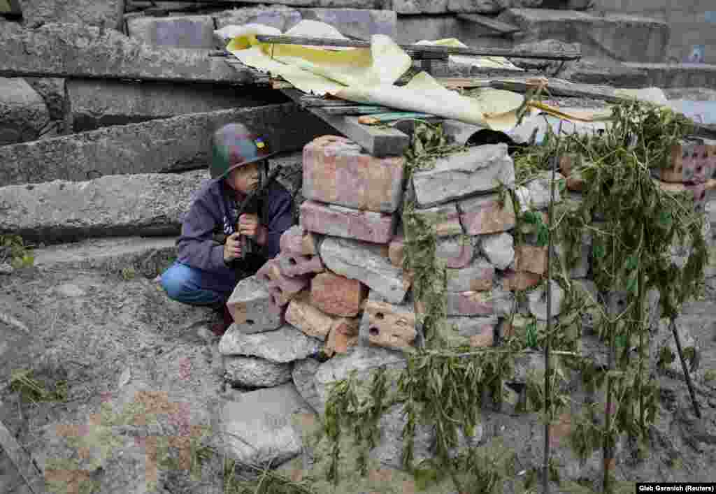 Andriy, aged 12, takes cover in a bunker made from discarded bricks in Stoyanka on May 22.&nbsp;