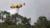 Një avion zjarrfikës mundohet të shuajë një zjarr në pyllin e Leirias, Portugali, 14 korrik 2022.