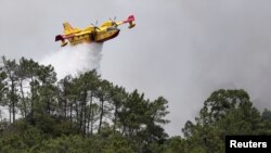 Një avion zjarrfikës mundohet të shuajë një zjarr në pyllin e Leirias, Portugali, 14 korrik 2022.