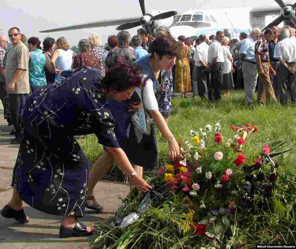 Hundreds of Ukrainians gathered near the charred grass and tarmac to pray and lay flowers several days later on July 29, 2002.