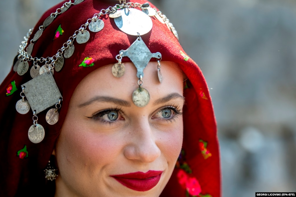 Një grua e veshur me veshje tradicionale duke shikuar festimet.