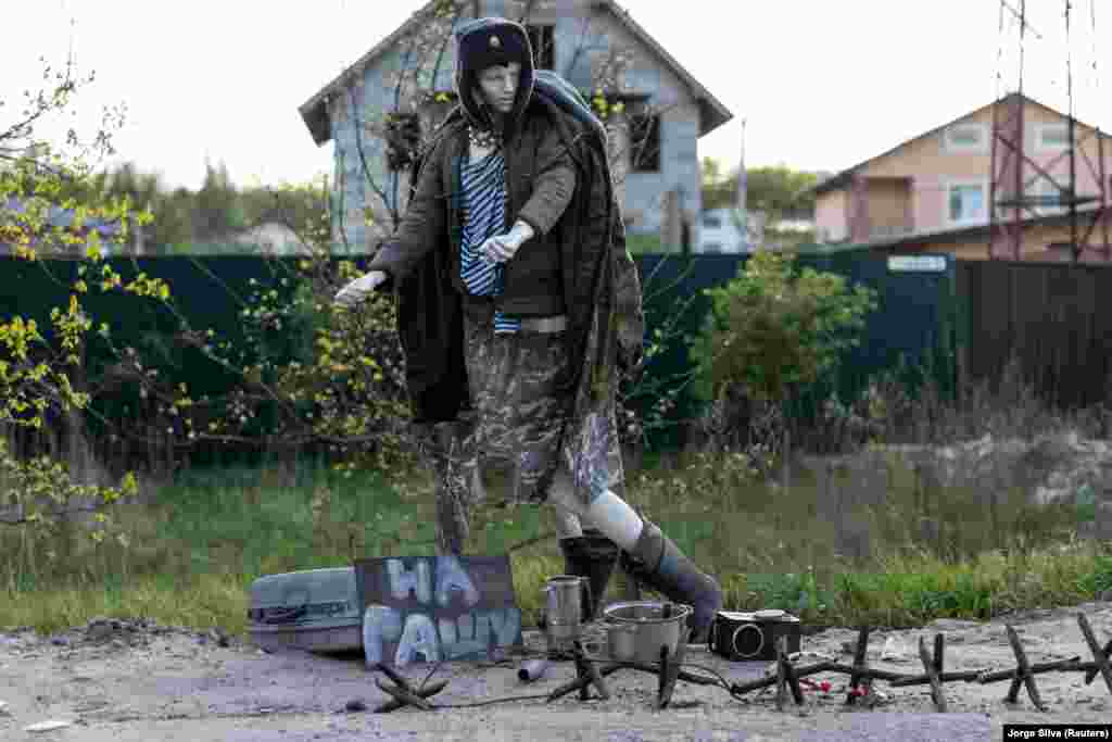 A mannequin depicting a Russian soldier is seen with a sign reading &quot;To Russia&quot; at an abandoned checkpoint in Borodyanka, outside Kyiv.