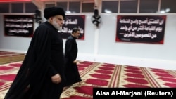 Liderul populist irakian Muqtada al-Sadr se plimbă după un discurs televizat în Najaf, Irak, 3 august 2022