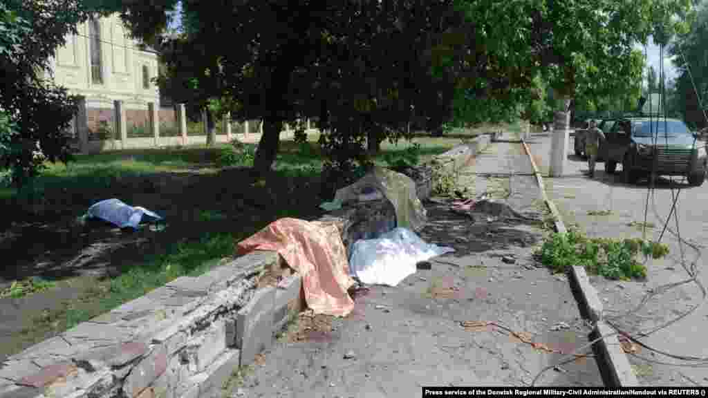 Тіла загиблих лежать поблизу зупинки громадського транспорту в місті Торецьку Донецької області, по якій вдарила російська армія, 4 серпня 2022 року &nbsp;