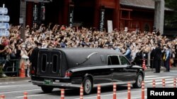 Një automjet që bartë trupin e ish-kryeministrit të ndjerë japonez Shinzo Abe, i cili u qëllua gjatë fushatës për zgjedhjet parlamentare, niset pas funeralit të tij në Tempullin Zojoji në Tokio, Japoni, 12 korrik 2022.