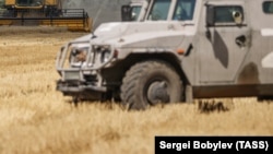 Військова машина Росії на українському полі під час збирання врожаю під час окупації в Херсонській області, 21 липня 2022 року