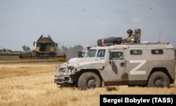 Orosz katonai járműből figyelik a betakarítást Herszon régióban 2022. július 21-én