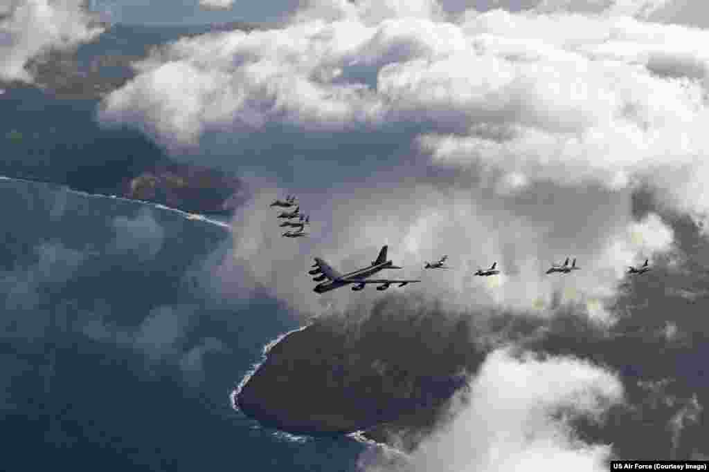 A US Air Force B-52 bomber flanked by fighter jets over Tinian Island in February 2024.The US Air Force says the rebuild of Tinian will give it the "theater posture" to respond to an attack, "anytime, anywhere in the Indo-Pacific." Some $409 million has been earmarked for the reconstruction project.
