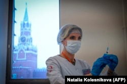 A health-care worker prepares a dose of Russia's Sputnik V COVID-19 vaccine to a patient at a vaccination center in the GUM department store in Moscow in January 2022.