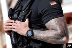 Jedan minhenski policajac je podneo tužbu nakon što mu je šef zabranio da istetovira havajski pozdrav "Aloha" na levu podlakticu, pisao je nemački Špigl 2018. godine. (na fotografiji pripadnik nemačke policije u Berlinu, april 2018. godine)