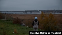 Жінка дивиться на зруйнований Антонівський міст через річку Дніпро після відступу Росії з Херсона, листопад 2022 року