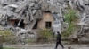 Мужчина проходит мимо разрушенного российскими обстрелами дома в Мариуполе, 9 ноября 2022 года