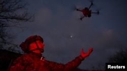 A member of the Сonsolidated Brigade Khyzhak (Predator) of the Ukrainian Patrol Police Department launches a drone at a position in a front line near the town of Toretsk, Donetsk region, Ukraine, on December 19.