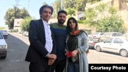 Rashno feltételes szabadlábra helyezése után ügyvédjével és fivérével egy teheráni utcán. 2022. augusztus 30. 