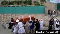 Mourners carry the body of a victim of a mosque bombing in Kabul that killed Hanafi cleric Amir Mohammad Kabuli and 20 more worshippers on August 17.