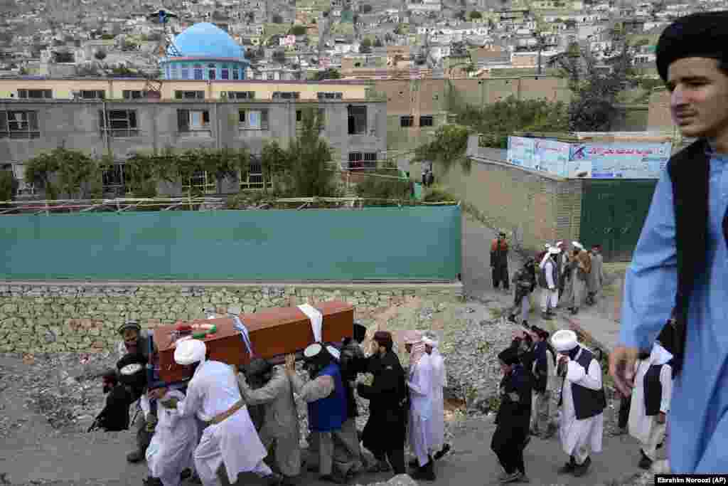 Mourners carry the body of a victim of a mosque bombing in Kabul on August 18. The blast during evening prayers on August 17 killed at least 21 people, including a prominent cleric, and wounded over two dozen others.