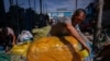 Kîrgîzstan, bazarul Dordoi: Un muncitor împachetează mărfuri pentru a le expedia în Kazahstan și Rusia. august 2022